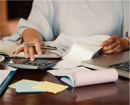 A person using a calculator and papers to do finances