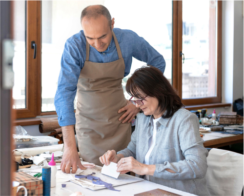 A man helping an older woman do crafts